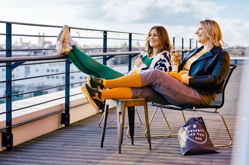 2 junge Frauen entspannen auf einer Dachterasse