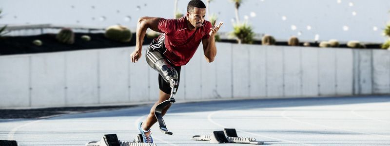 Ein Mann mit einer Sportprothese rennt auf einer Laufbahn