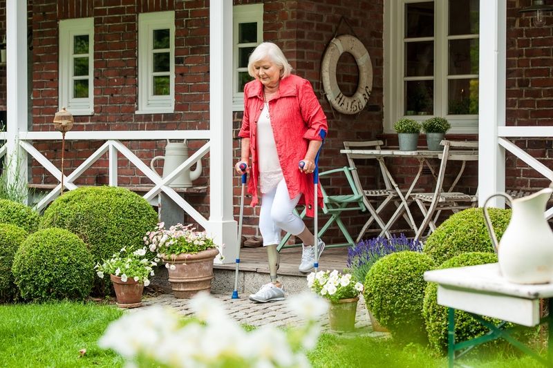 Eine Frau mit Prothese und Krüken geht die Treppe runter